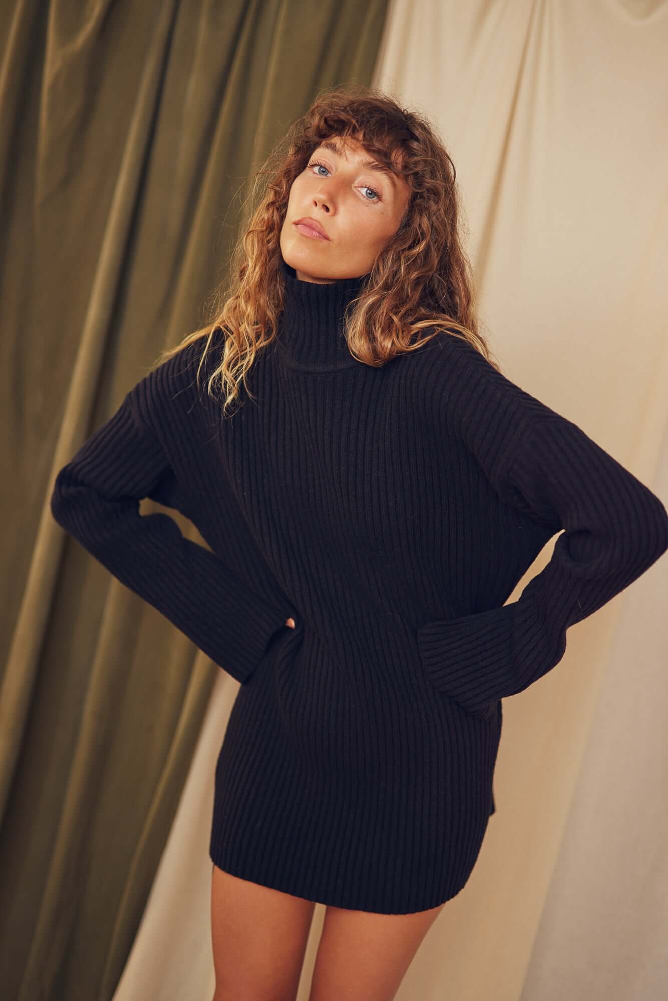 Model wearing a Black Heavy Knitted Wool Tunic featuring relaxed fit and ribbed texture.