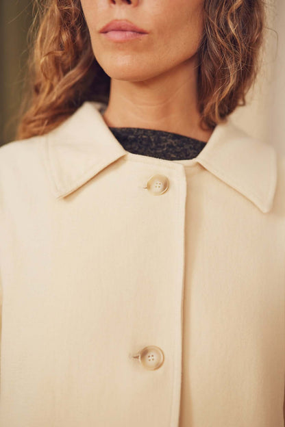 Close-up of a model showcasing the Oat Organic Cotton Long Wide Coat with eco-friendly buttons.