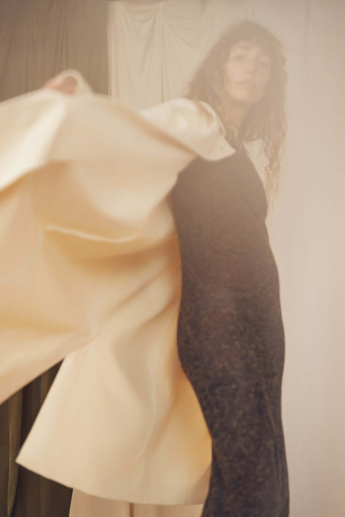 Model showcasing the Oat Organic Cotton Long Wide Coat over a dress, demonstrating elegance and style.