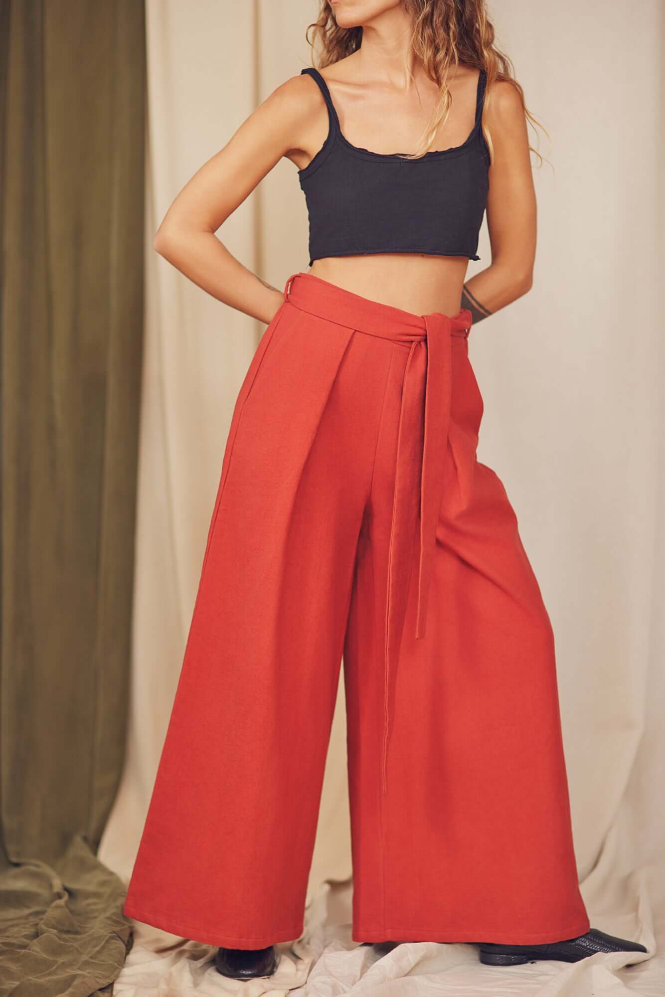 Rust Organic Cotton Wide Trousers styled with a black crop top, showcasing their voluminous silhouette and detachable belt.