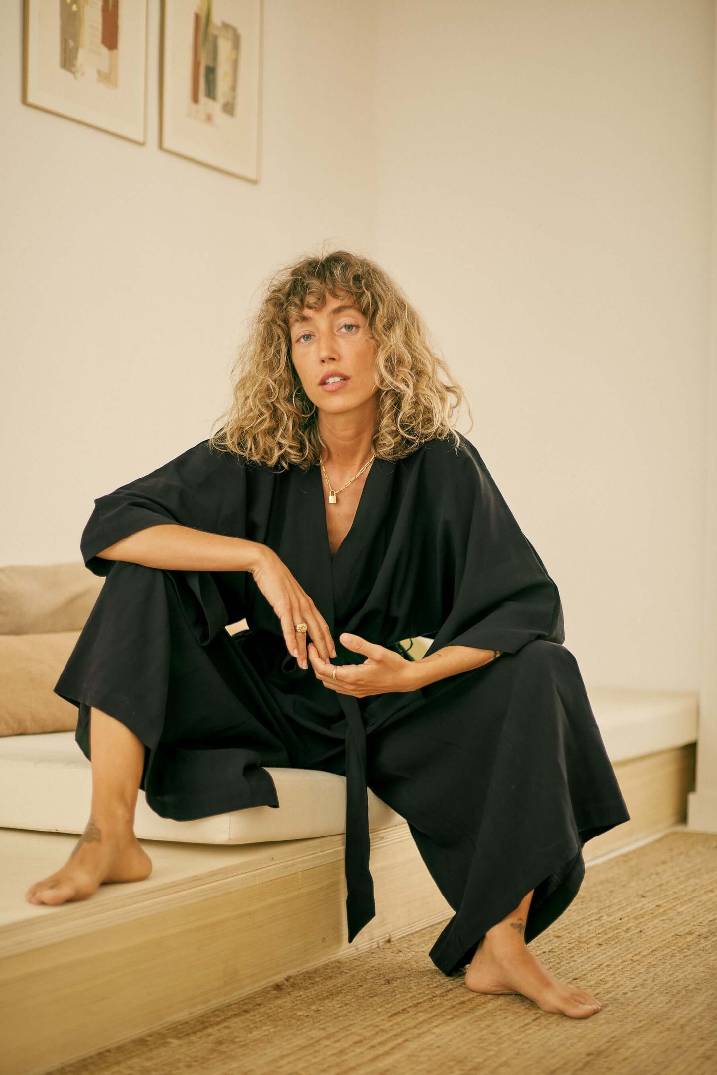 Woman wearing a Tencel Kimono Jumpsuit in Black, showcasing its relaxed silhouette and stylish design.