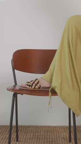 Wide Ecovero Trousers in Soft Olive displayed on a seated model, showcasing relaxed styles with elegant footwear.