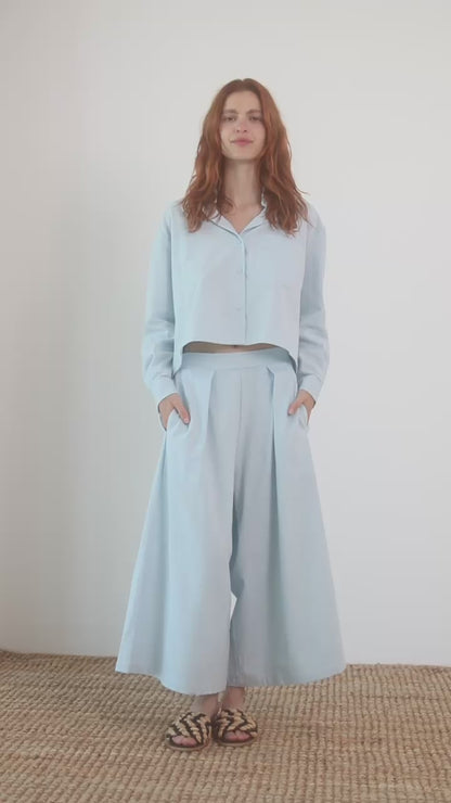 Model wearing Organic Cotton Wide Culottes in Pale Blue with a matching cropped top and sandals.