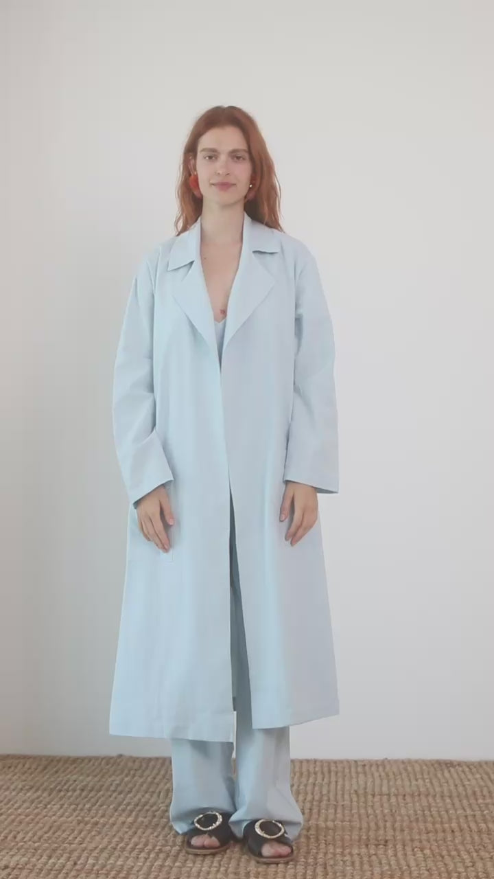 Lightweight Organic Cotton Trench Coat in Pale Blue displayed on a model, showcasing its relaxed silhouette and soft fabric.