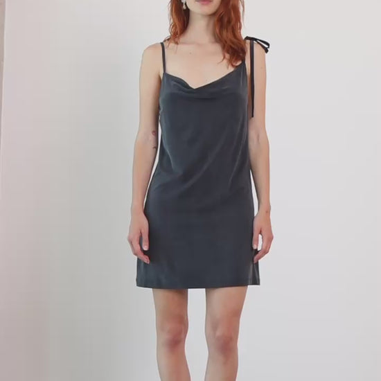 Cupro Drape Slip Mini Dress in Slate Black worn by model, featuring draped neckline and adjustable straps.