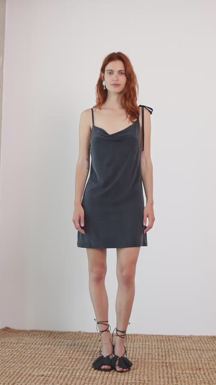 Cupro Drape Slip Mini Dress in Slate Black worn by model, featuring draped neckline and adjustable straps.