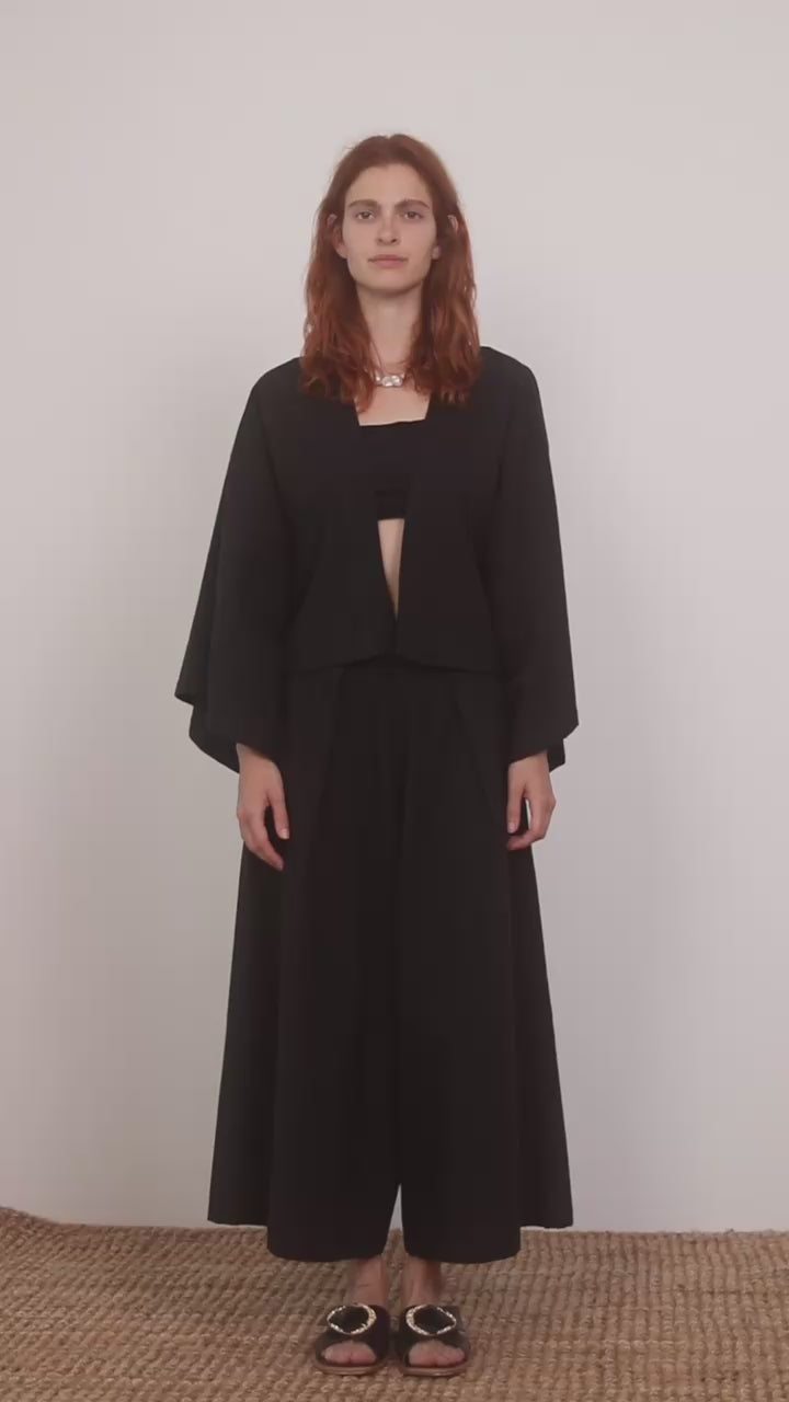 Model wearing Organic Cotton Kimono Jacket in Black paired with wide culottes, showcasing a relaxed silhouette.