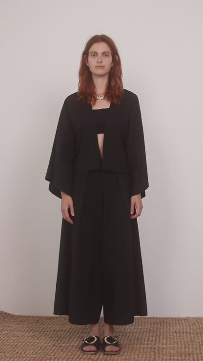 Model wearing Organic Cotton Kimono Jacket in Black paired with wide culottes, showcasing a relaxed silhouette.