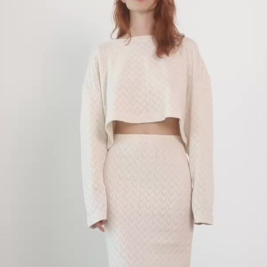 Model showcasing a Crochet Organic Cotton Midi Skirt and matching top in ecru, highlighting texture and modern style.