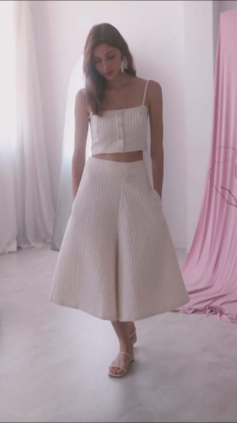 Model wearing ECRU WAFFLE CROP TOP with matching culottes in airy surroundings.