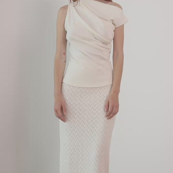 Model wearing a Banana Pineapple Drape Neckline Top in Ecru paired with a textured white skirt.